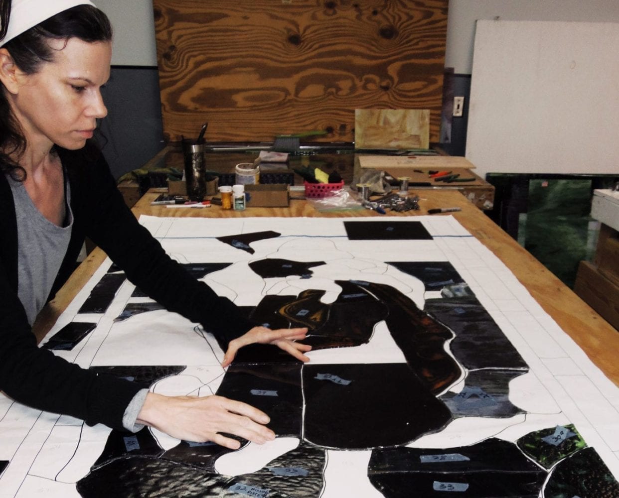 A stained glass artist builds a window